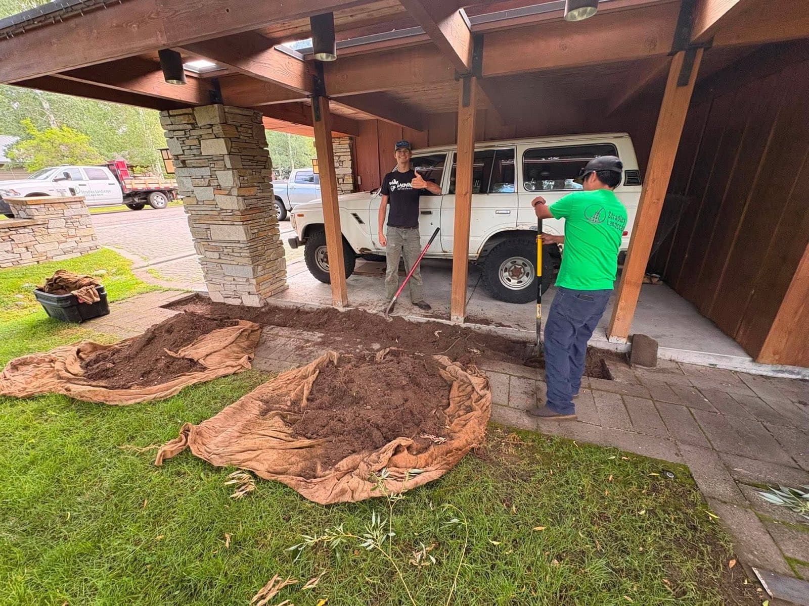 Stradley Landscape crew planting balled and burlapped trees at a Jackson home